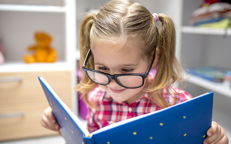 Bambina sorridente che legge un testo in lingua inglese presso la British School di Isernia