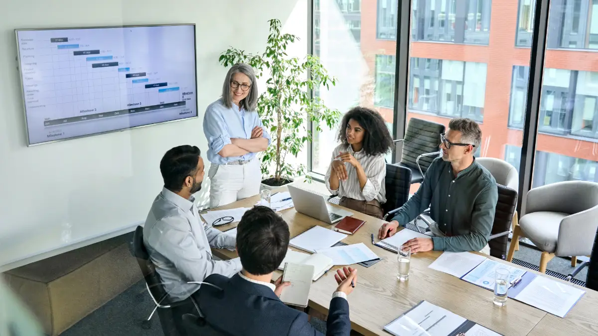 Professionisti utilizzano i phrasal verbs del Business English durante una riunione aziendale.