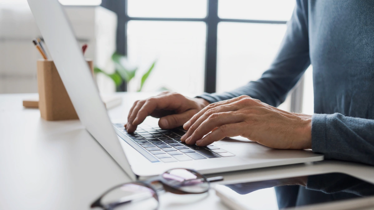 Professionista che scrive un'email formale in inglese su un computer portatile.