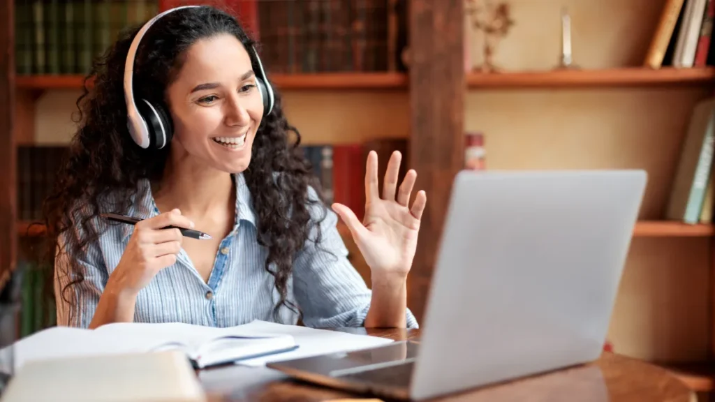 Studente concentrato che indossa cuffie con microfono durante una classe virtuale.